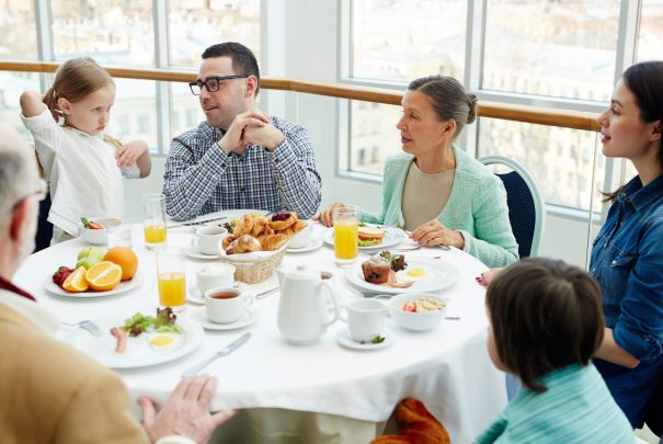 Big family having talk by breakfast in restaurant